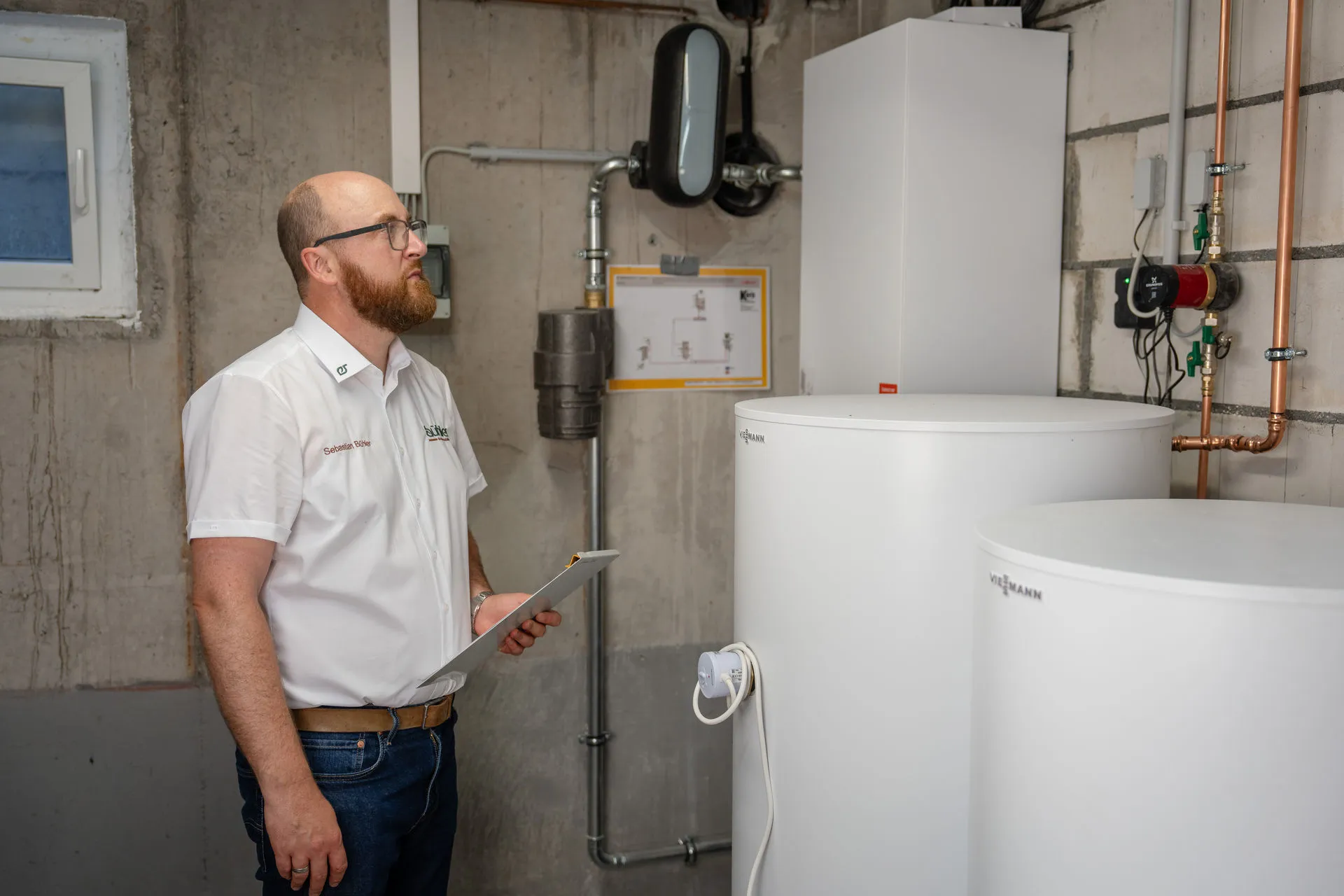 Techniker vor Viessmann Heizanlage und Rohrsystem
