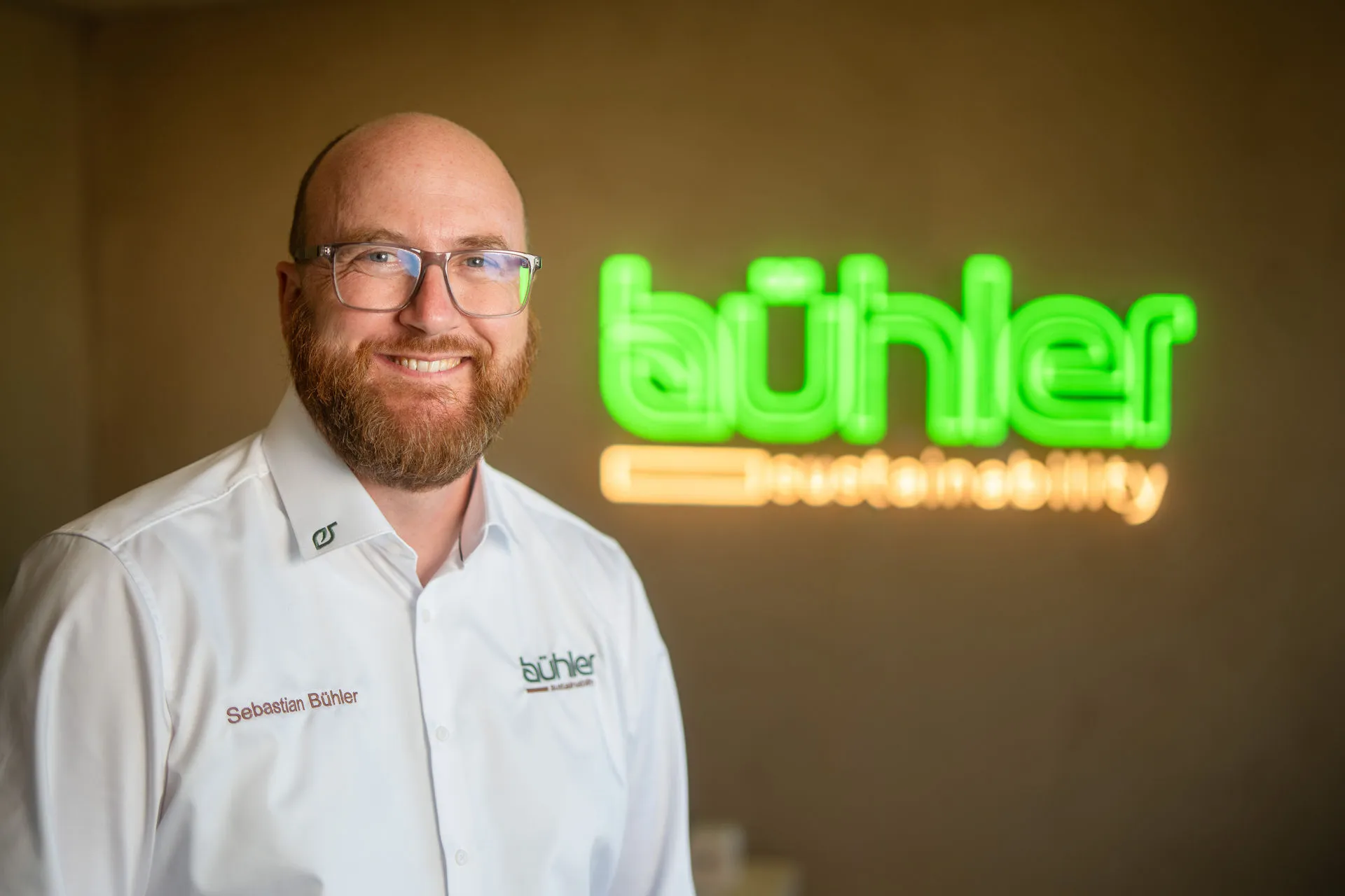 Sebastian Bühler vor dem bühler sustainability Neon-Schild